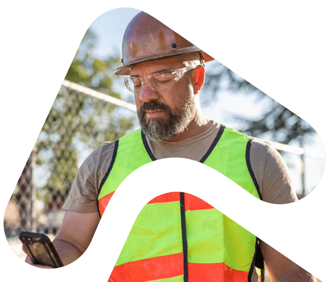 Construction worker looks at phone